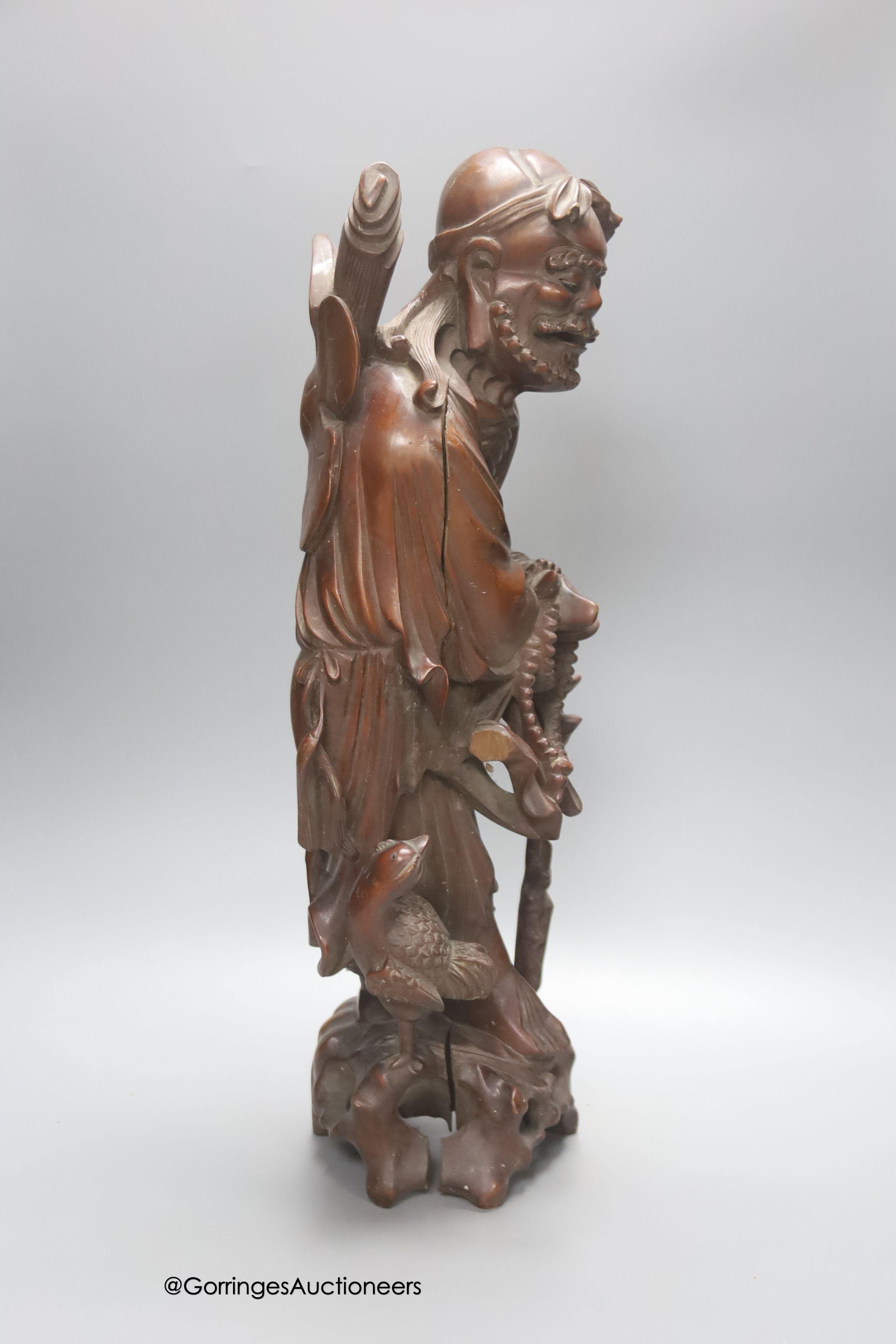 An early 20th century Chinese hardwood carving of a luohan figure, height 52cm